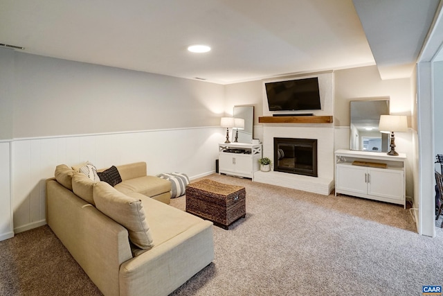 carpeted living area with a brick fireplace and visible vents