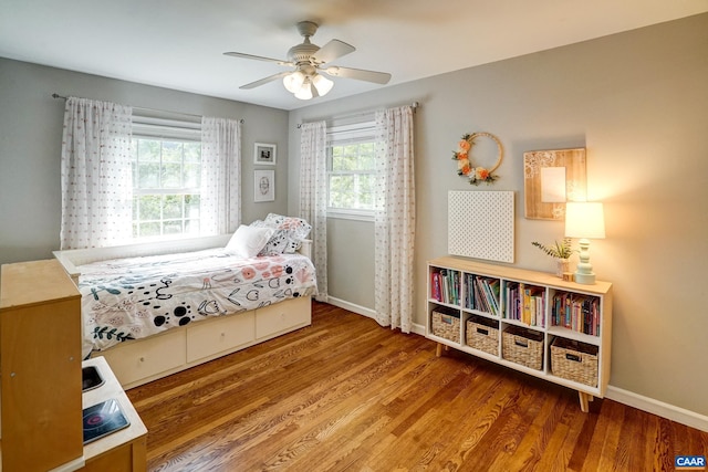 bedroom featuring a ceiling fan, baseboards, and wood finished floors