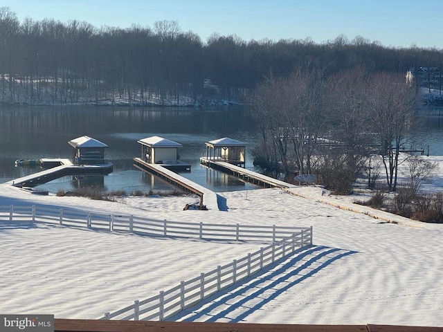 exterior space with a water view, fence, and a boat dock