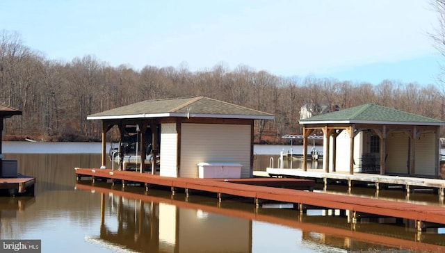 dock area featuring a forest view, a water view, and boat lift