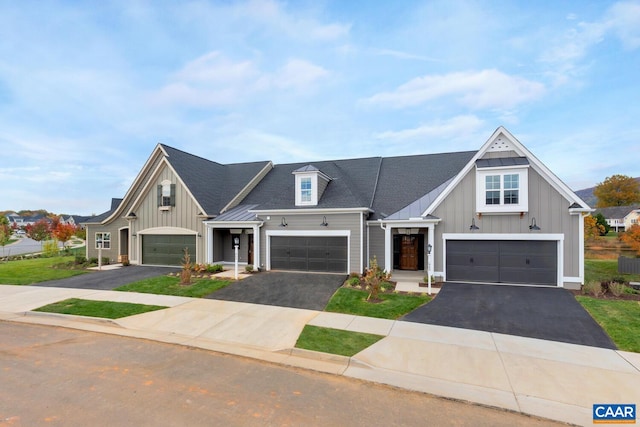 view of front of house with a garage, roof with shingles, aphalt driveway, and board and batten siding