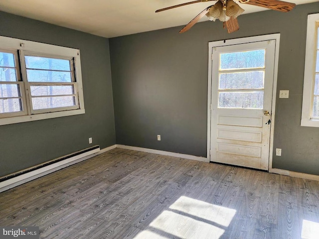 interior space with a wealth of natural light, baseboards, and wood finished floors