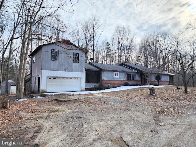 view of front facade featuring dirt driveway and brick siding