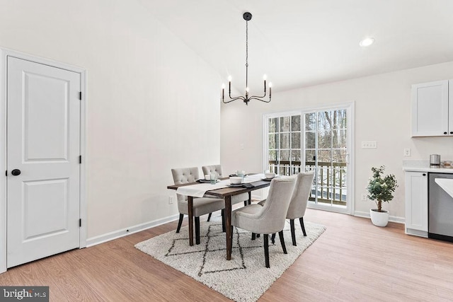 dining space featuring vaulted ceiling, a chandelier, and light wood-type flooring