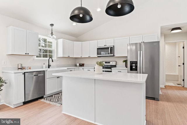 kitchen with light hardwood / wood-style flooring, hanging light fixtures, stainless steel appliances, a center island, and white cabinets