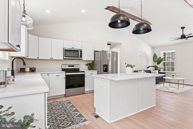 kitchen with sink, light hardwood / wood-style flooring, ceiling fan, stainless steel appliances, and white cabinets