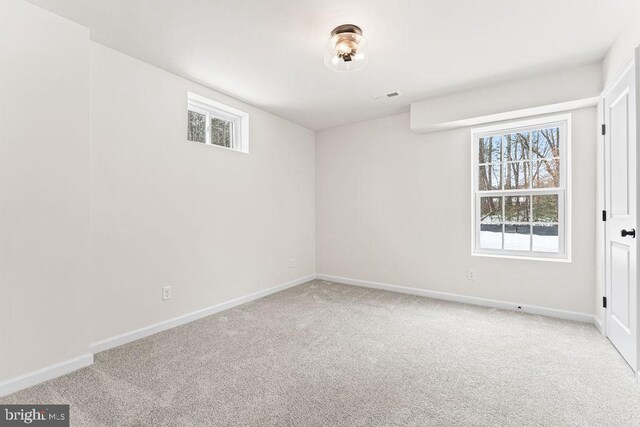 empty room with plenty of natural light and light carpet