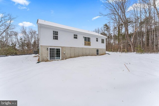 snow covered house featuring cooling unit