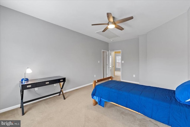 carpeted bedroom featuring attic access, baseboards, and a ceiling fan