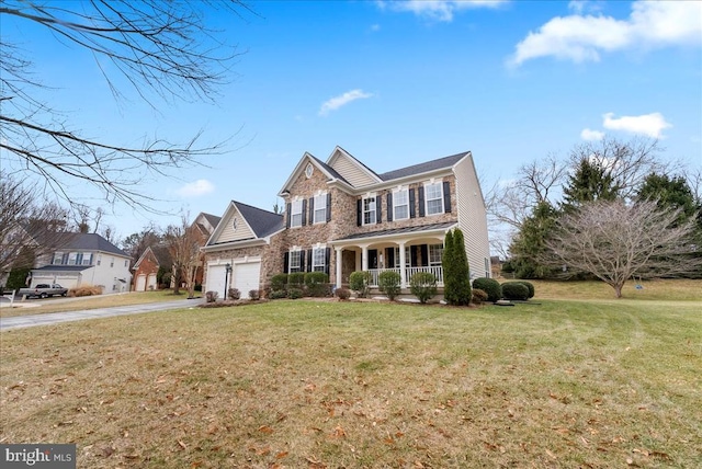 traditional-style house with a garage, driveway, a front lawn, and a porch