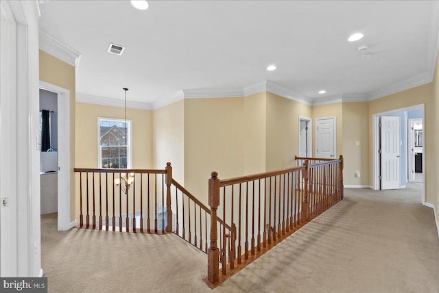 hallway with carpet floors, ornamental molding, an upstairs landing, and baseboards