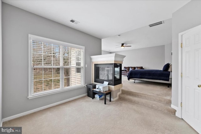 bedroom featuring a multi sided fireplace, carpet flooring, visible vents, and baseboards