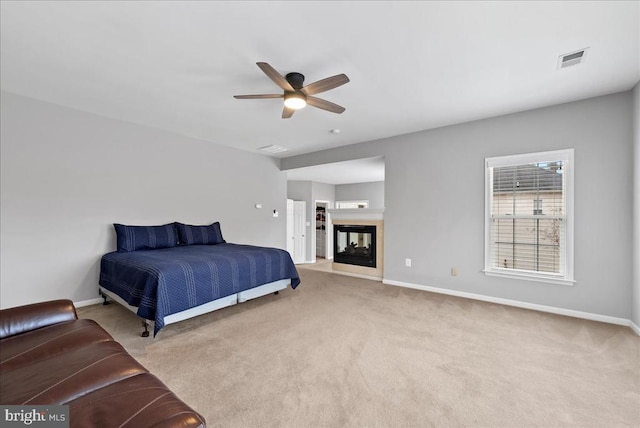 carpeted bedroom featuring visible vents, baseboards, and a multi sided fireplace