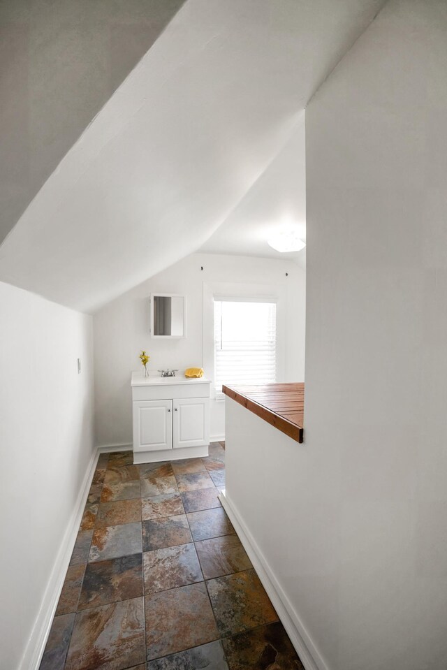 bathroom featuring sink and vaulted ceiling