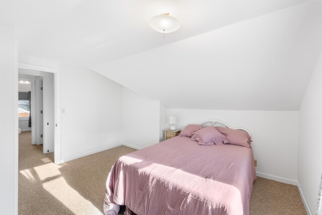 carpeted bedroom featuring vaulted ceiling