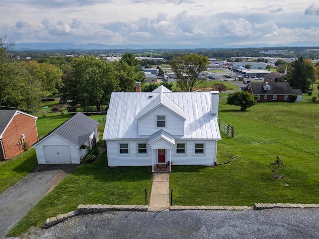 view of front facade featuring a garage, an outbuilding, and a front yard