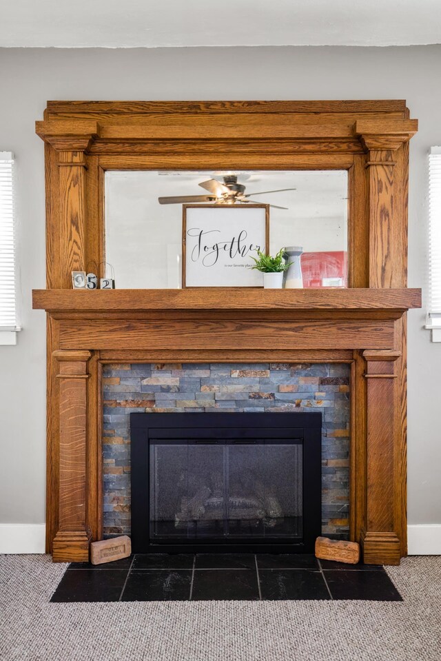 details featuring a stone fireplace and carpet