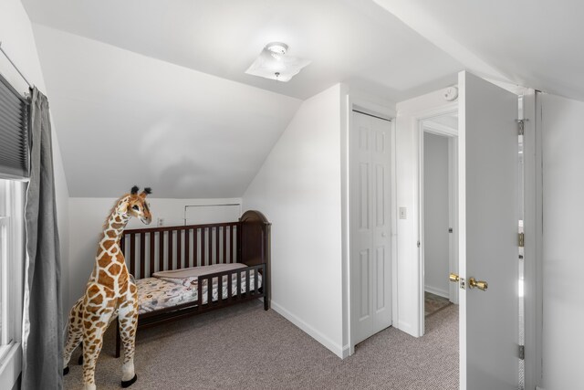 bedroom with vaulted ceiling and light carpet