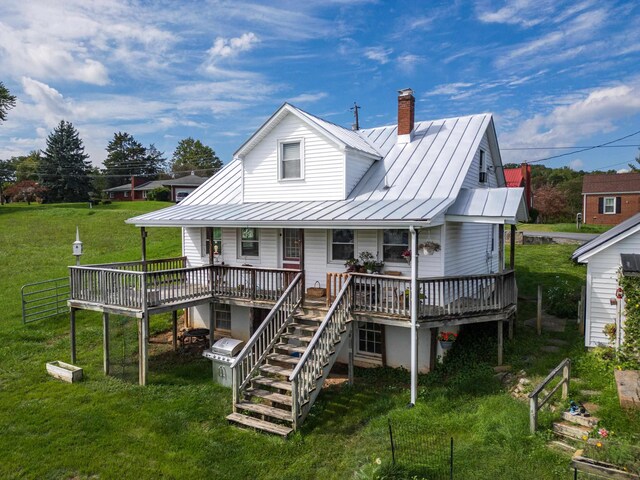 rear view of property featuring a deck and a lawn