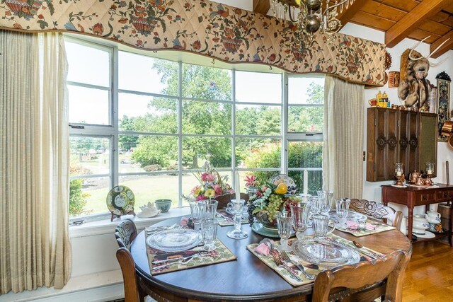 dining area with vaulted ceiling with beams, hardwood / wood-style floors, and wood ceiling