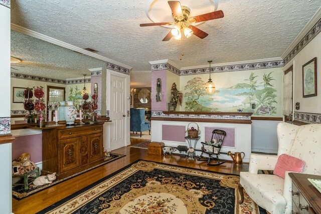 sitting room with crown molding, ceiling fan, wood-type flooring, and a textured ceiling