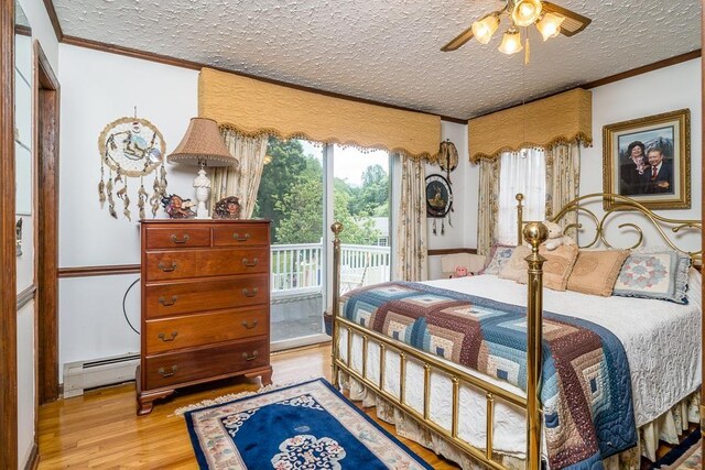 bedroom with a baseboard heating unit, access to exterior, ornamental molding, light hardwood / wood-style floors, and a textured ceiling