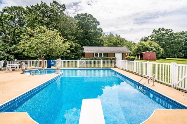 view of pool with a patio, a storage shed, and a diving board