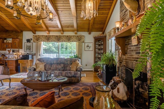 living room featuring lofted ceiling with beams, a baseboard radiator, hardwood / wood-style flooring, a notable chandelier, and wood ceiling