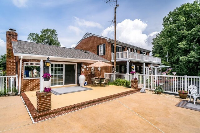 rear view of house with a balcony and a patio area