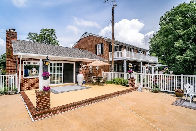 rear view of house with a balcony and a patio area