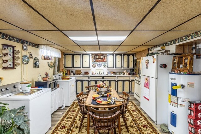 kitchen featuring washer / dryer, electric water heater, white fridge, and a drop ceiling