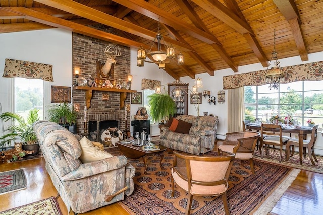 living room featuring hardwood / wood-style flooring, a healthy amount of sunlight, a fireplace, and high vaulted ceiling