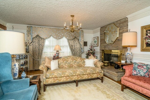 living room with ornamental molding, a large fireplace, a notable chandelier, and a textured ceiling