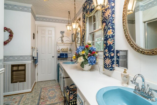 bathroom featuring vanity, ornamental molding, and a textured ceiling