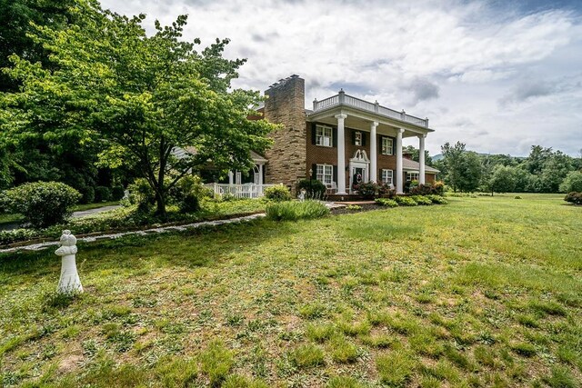 greek revival inspired property featuring a front lawn