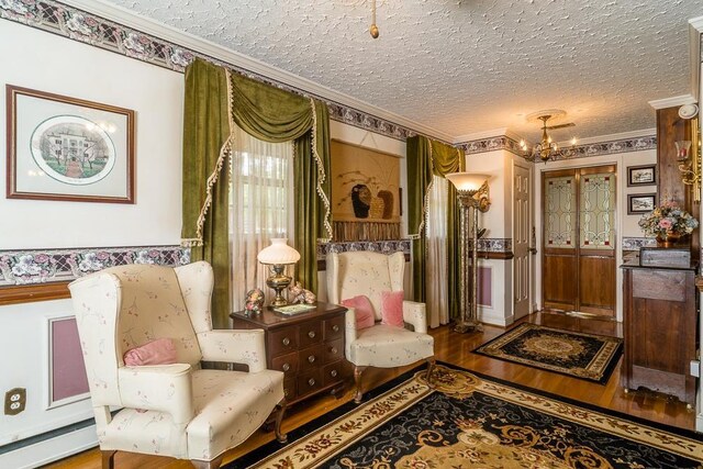 living area featuring an inviting chandelier, a baseboard radiator, hardwood / wood-style flooring, ornamental molding, and a textured ceiling