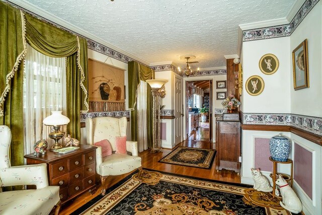 interior space featuring crown molding, wood-type flooring, a chandelier, and a textured ceiling