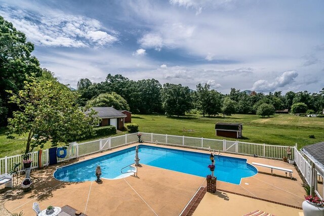 view of pool featuring a diving board, a lawn, and a patio area