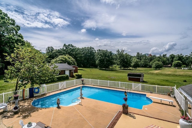 view of pool featuring a diving board, a lawn, and a patio area