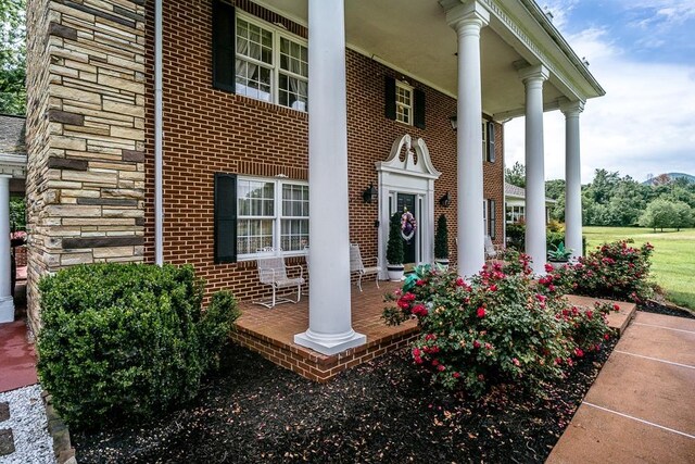 view of exterior entry featuring covered porch