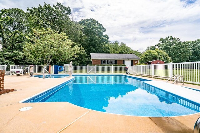 view of swimming pool featuring an outdoor structure and a patio