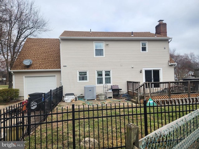 rear view of property with central AC, a lawn, a chimney, a fenced backyard, and a deck