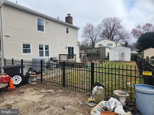 rear view of house featuring a chimney, a fenced backyard, a yard, an outdoor structure, and a storage unit