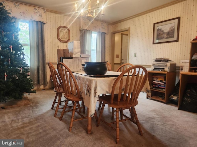 carpeted dining space featuring an inviting chandelier, ornamental molding, and wallpapered walls