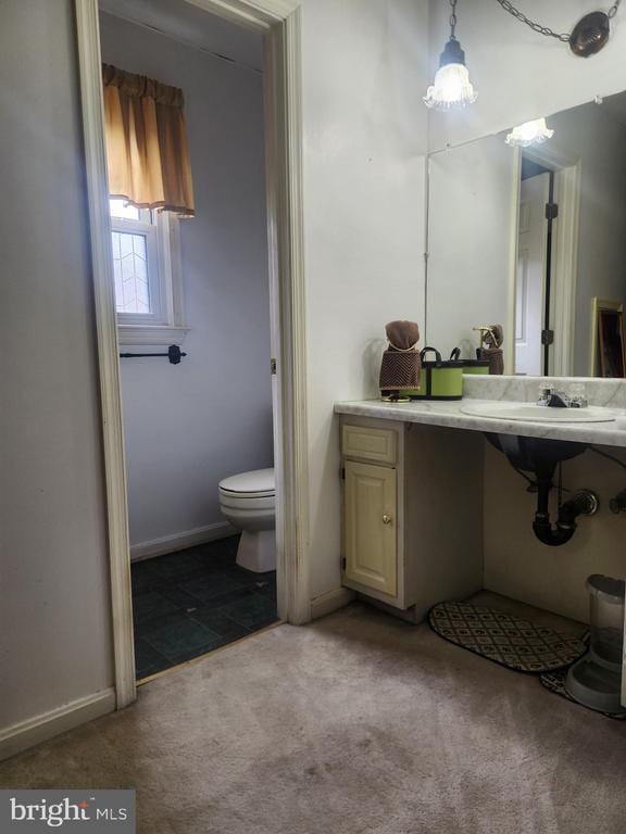 bathroom with a sink, baseboards, and toilet