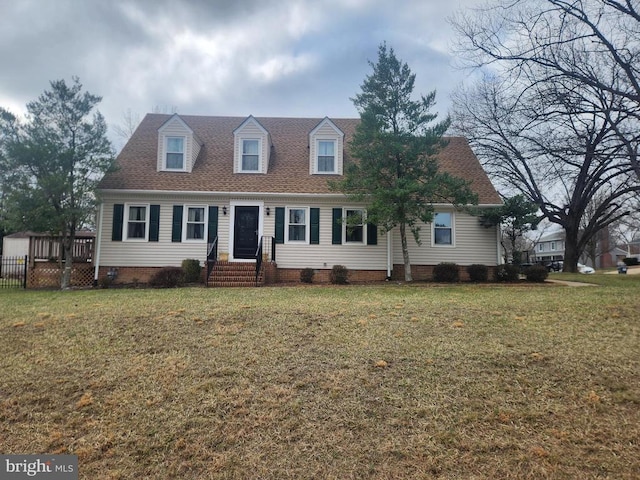 new england style home featuring crawl space, a shingled roof, and a front yard