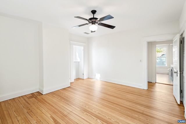 unfurnished room featuring baseboards, visible vents, a ceiling fan, and light wood-style flooring