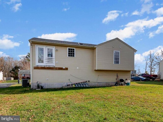 back of property with a yard and central AC unit