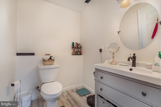 bathroom featuring wood-type flooring, vanity, and toilet