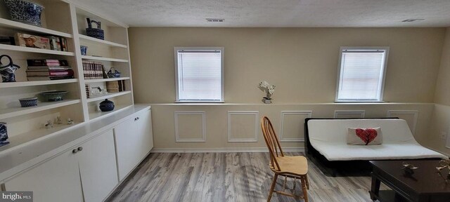 dining area featuring plenty of natural light, a textured ceiling, and light hardwood / wood-style flooring